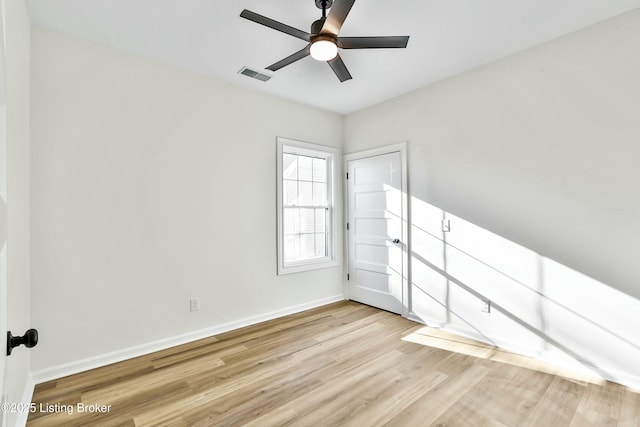 unfurnished room with light wood-type flooring, baseboards, visible vents, and ceiling fan