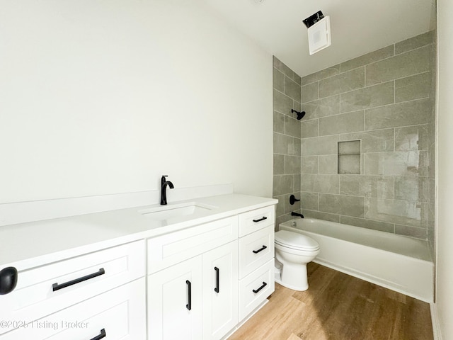 bathroom featuring toilet, shower / bathing tub combination, wood finished floors, and vanity