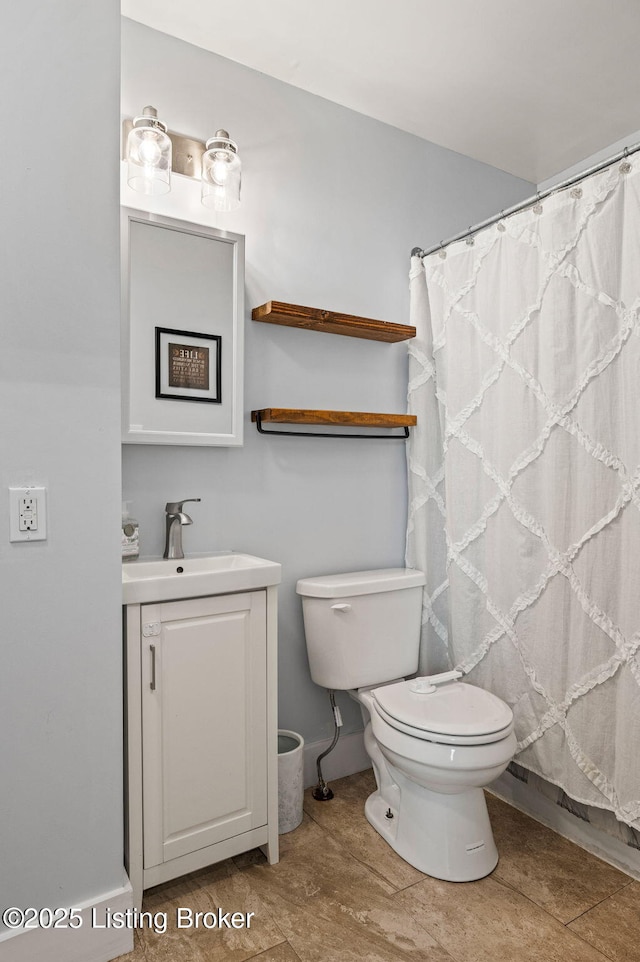 bathroom featuring toilet, curtained shower, and vanity