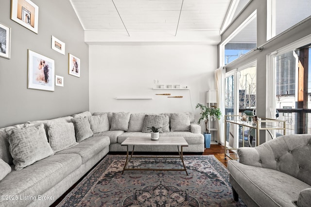 living room featuring a towering ceiling and wood finished floors