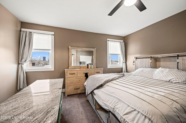 bedroom with dark carpet and a ceiling fan