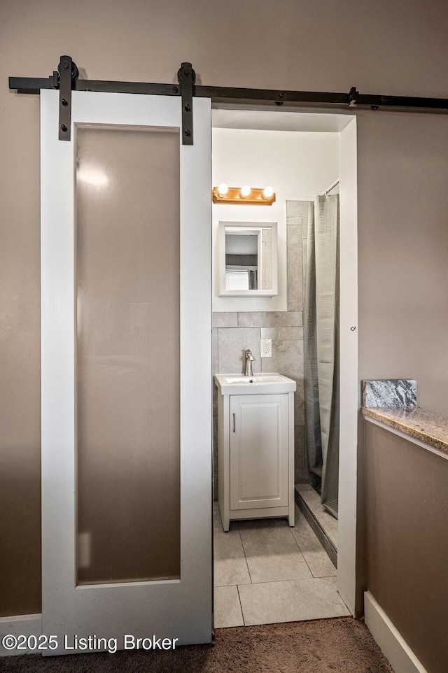 full bath featuring a shower with shower curtain, tile patterned flooring, tile walls, and vanity