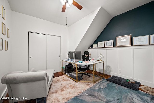 office with lofted ceiling, a ceiling fan, a decorative wall, and wood finished floors