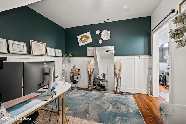 office featuring a decorative wall, wood finished floors, and wainscoting