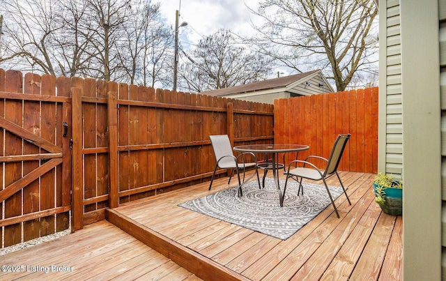 deck with outdoor dining area and fence