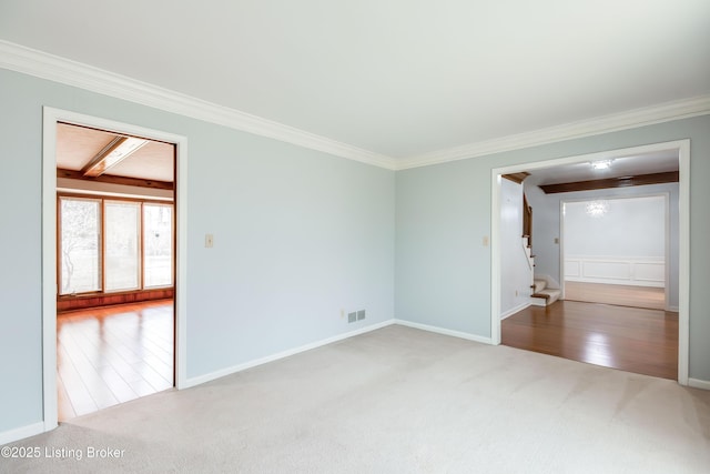 empty room with carpet, stairs, visible vents, and crown molding