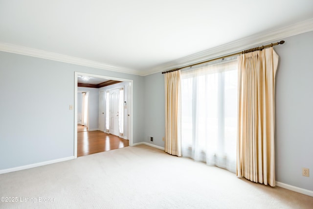 unfurnished room featuring carpet floors, crown molding, and baseboards