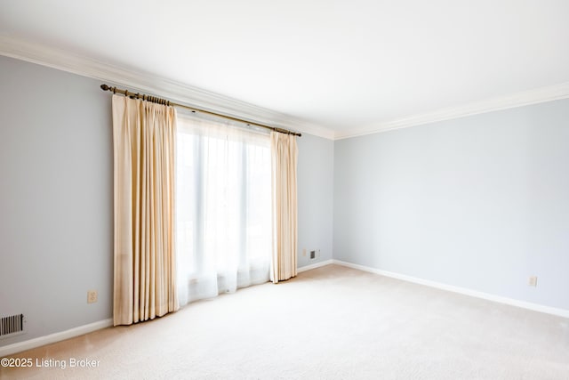 empty room with ornamental molding, carpet flooring, visible vents, and baseboards