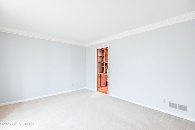 spare room with light carpet, baseboards, visible vents, and ornamental molding