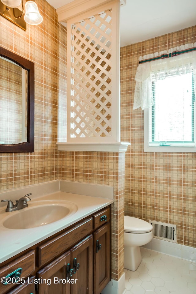 bathroom featuring toilet, vanity, visible vents, and tile patterned floors