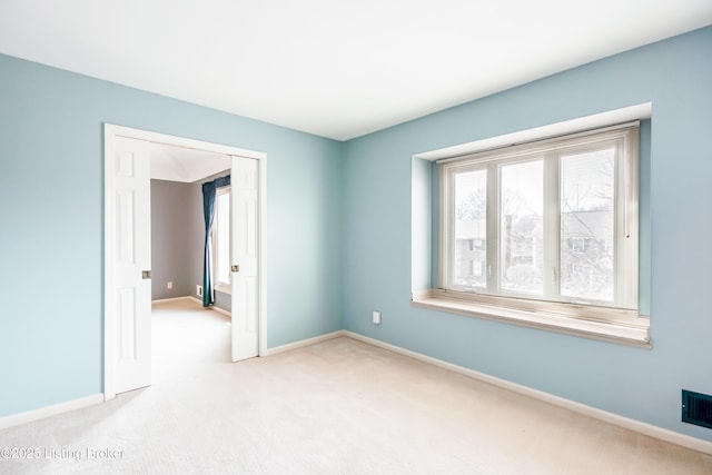 empty room with light carpet and baseboards