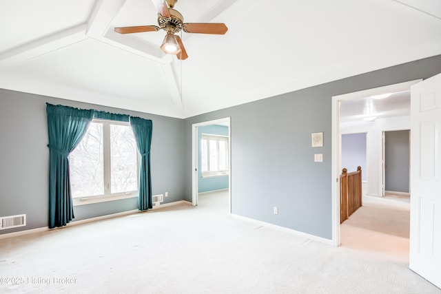 spare room with lofted ceiling with beams, light carpet, visible vents, and baseboards