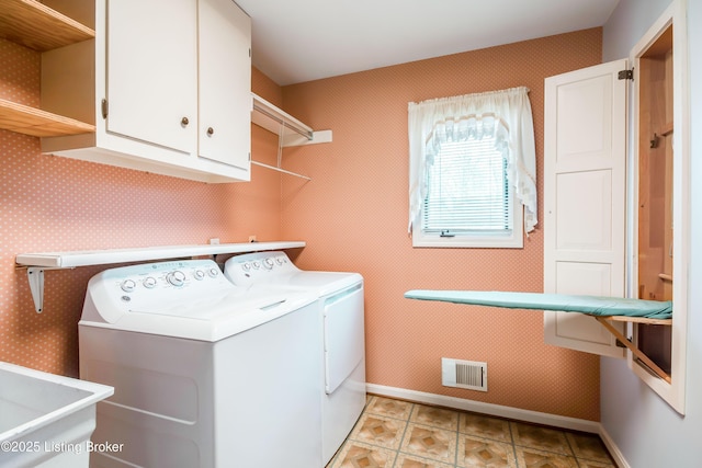 laundry room with baseboards, cabinet space, visible vents, and washer and dryer