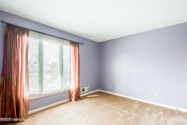 empty room featuring baseboards, visible vents, and carpet flooring