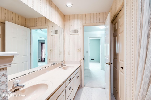 bathroom featuring a sink, visible vents, and wallpapered walls