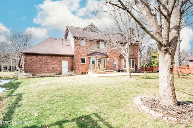 back of property featuring a yard, brick siding, and fence