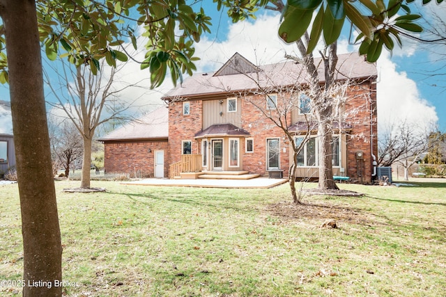 rear view of house featuring central air condition unit, a yard, and brick siding