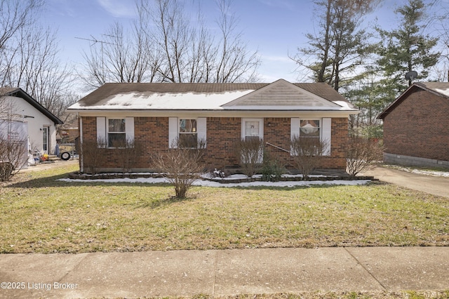 ranch-style house with a front yard and brick siding