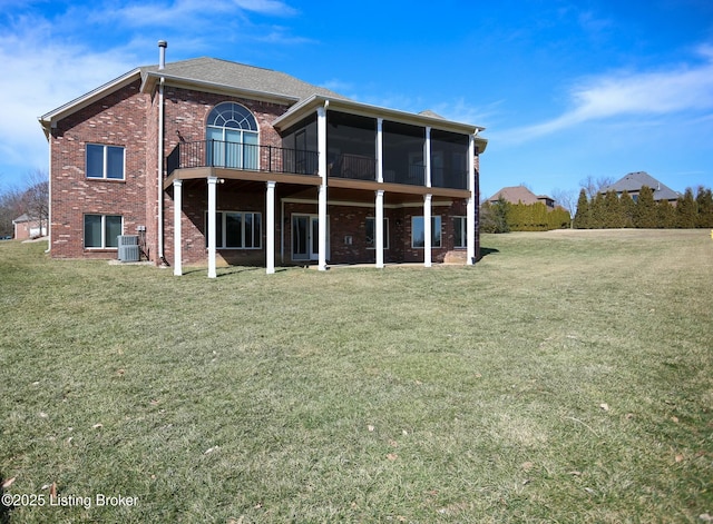 back of house with a sunroom, cooling unit, a lawn, and brick siding