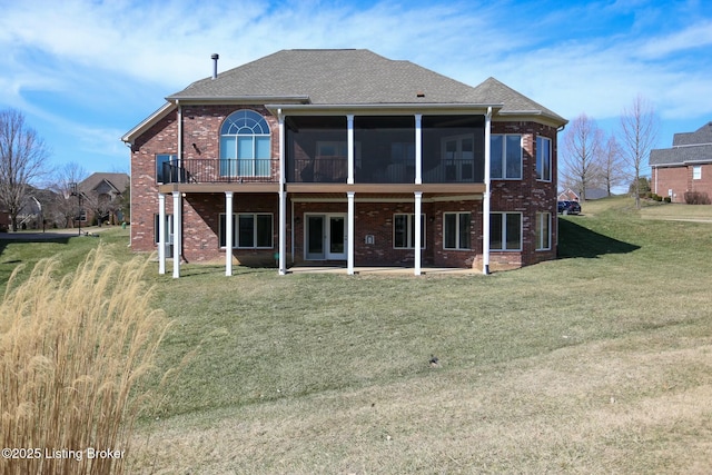 back of property featuring french doors, a sunroom, a yard, a patio area, and brick siding