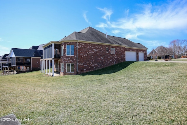 view of home's exterior featuring brick siding, a lawn, an attached garage, and roof with shingles