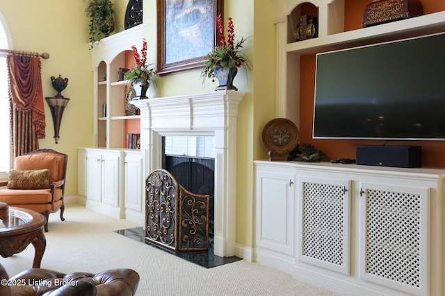 sitting room with carpet floors and a fireplace with flush hearth