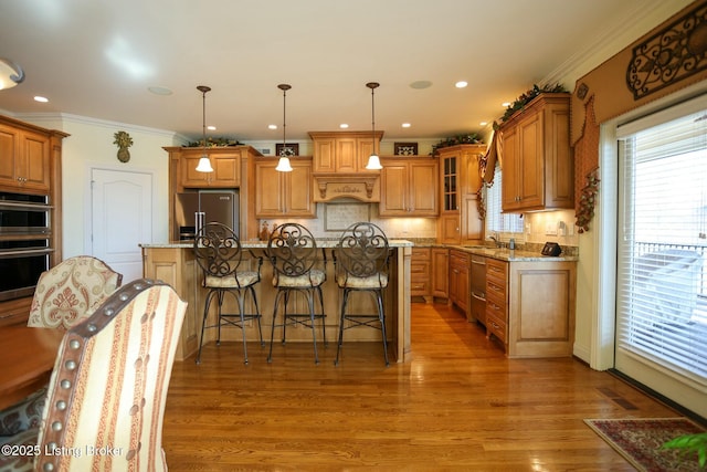 kitchen featuring appliances with stainless steel finishes, brown cabinetry, backsplash, and light stone counters