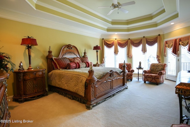 carpeted bedroom with ornamental molding, ceiling fan, a tray ceiling, and access to exterior