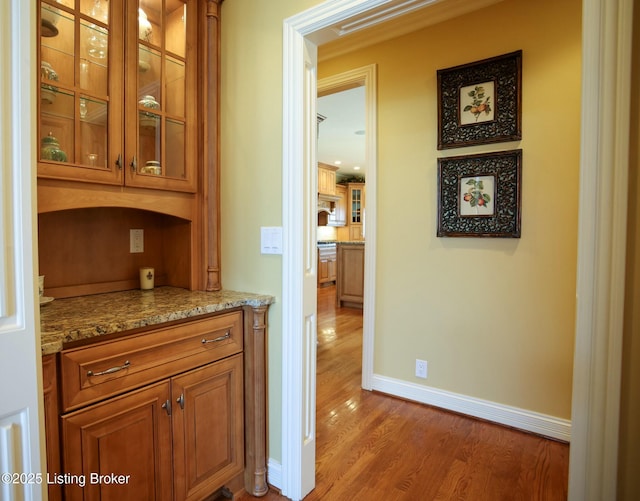 hall featuring baseboards and light wood finished floors