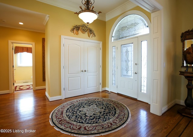 foyer featuring ornamental molding, baseboards, and wood finished floors