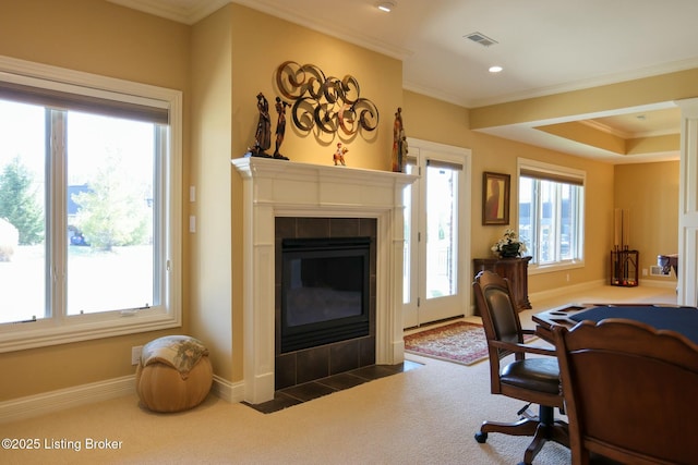 office space with carpet, visible vents, crown molding, and a tiled fireplace