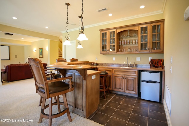 bar featuring stairway, ornamental molding, a sink, dark tile patterned floors, and indoor wet bar