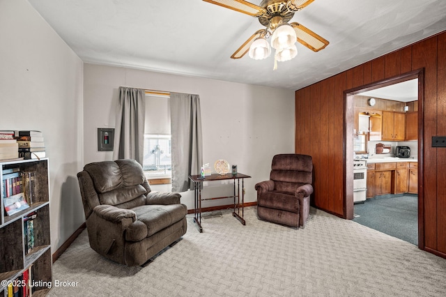 sitting room featuring carpet floors, baseboards, and a ceiling fan