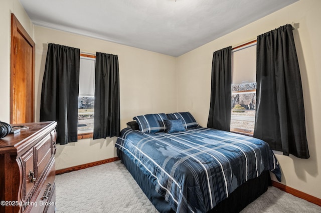 bedroom featuring carpet flooring, baseboards, and multiple windows