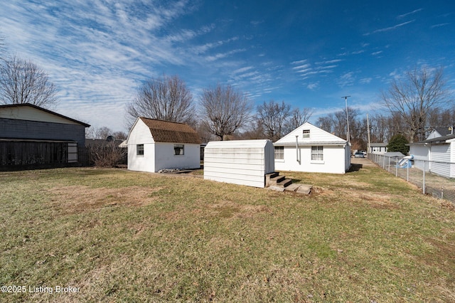 view of yard with an outbuilding, a shed, and fence