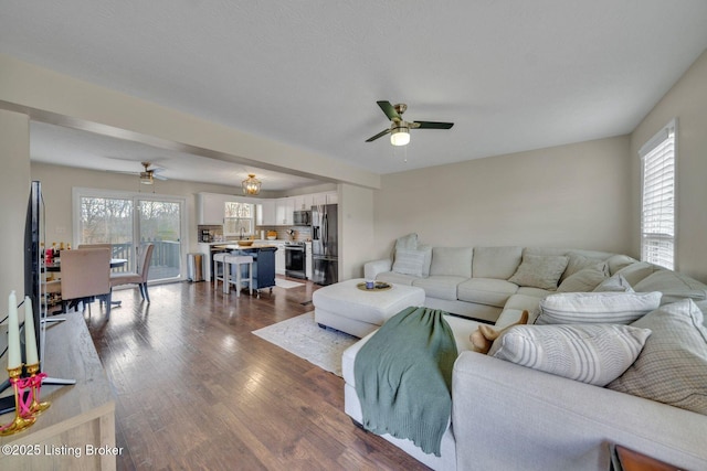 living area with dark wood-style floors and a ceiling fan