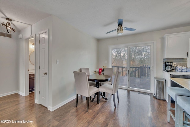 dining room with baseboards, visible vents, a ceiling fan, dark wood-style floors, and a textured ceiling