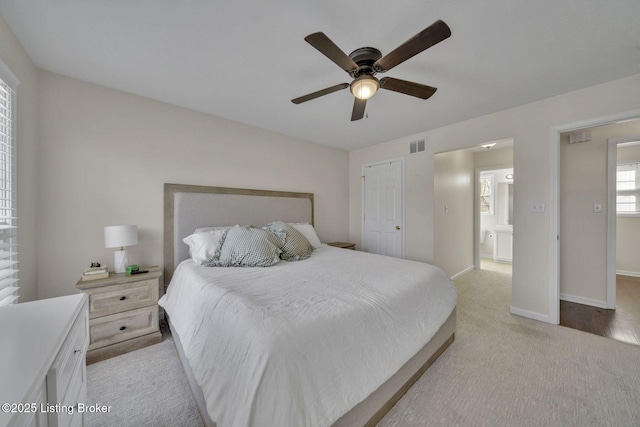 bedroom featuring a ceiling fan, light colored carpet, visible vents, and baseboards