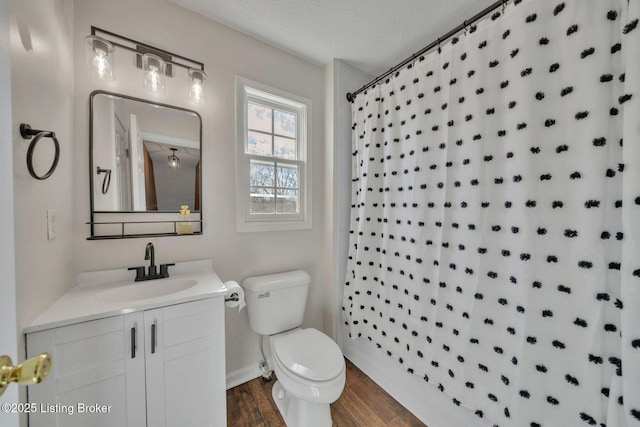 bathroom featuring a textured ceiling, toilet, a shower with shower curtain, wood finished floors, and vanity