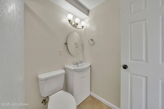 half bathroom featuring toilet, tile patterned floors, baseboards, and vanity