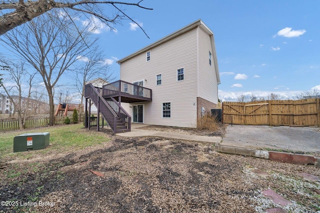 rear view of property with stairs, fence, a patio, and a wooden deck