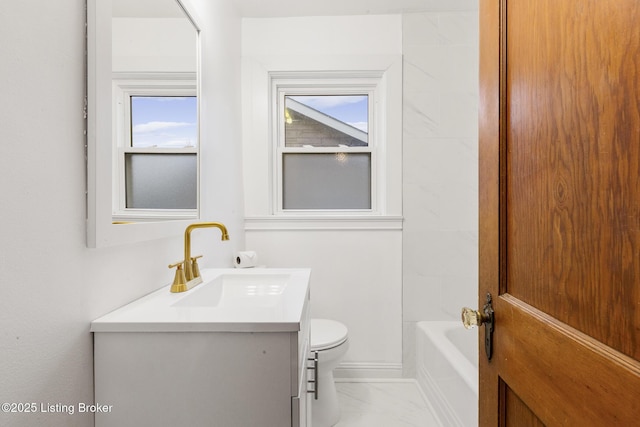 full bathroom featuring a healthy amount of sunlight, marble finish floor, toilet, and vanity