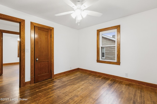 empty room featuring ceiling fan, baseboards, and wood finished floors