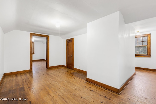 bonus room with vaulted ceiling, wood-type flooring, and baseboards