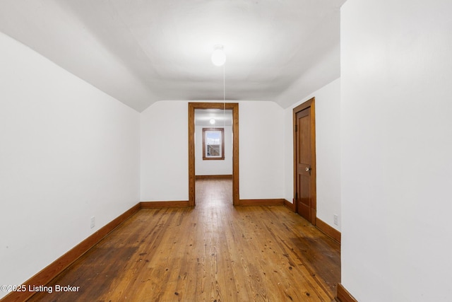 bonus room with baseboards, vaulted ceiling, and hardwood / wood-style floors