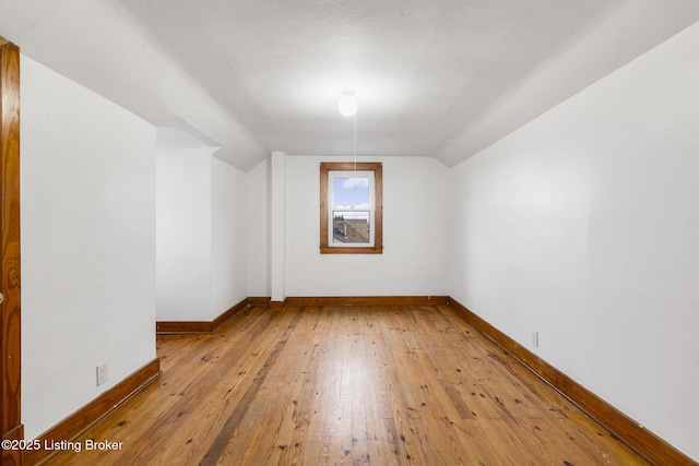 bonus room featuring baseboards, vaulted ceiling, and hardwood / wood-style floors