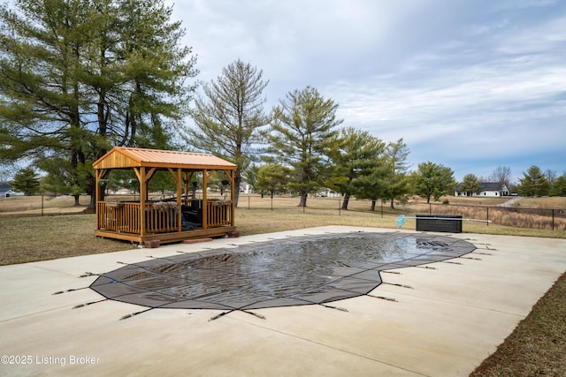 view of swimming pool featuring a deck, a patio, fence, a gazebo, and a fenced in pool