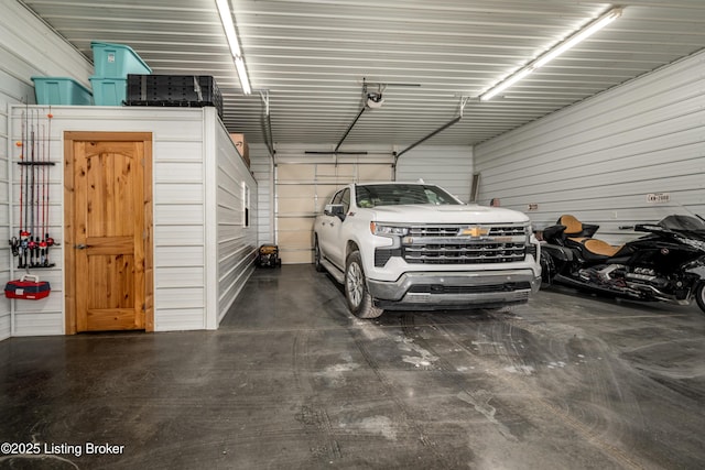 garage with a garage door opener and metal wall