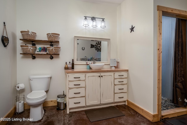 bathroom featuring walk in shower, vanity, toilet, and baseboards