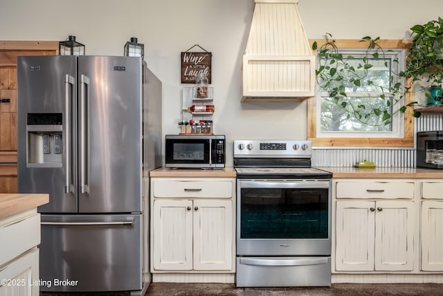 kitchen featuring premium range hood and stainless steel appliances